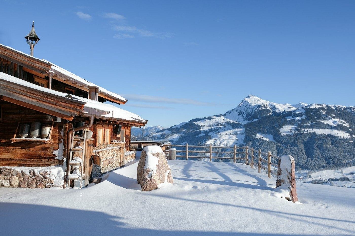 Holzhaus im Schnee mit Bergblick