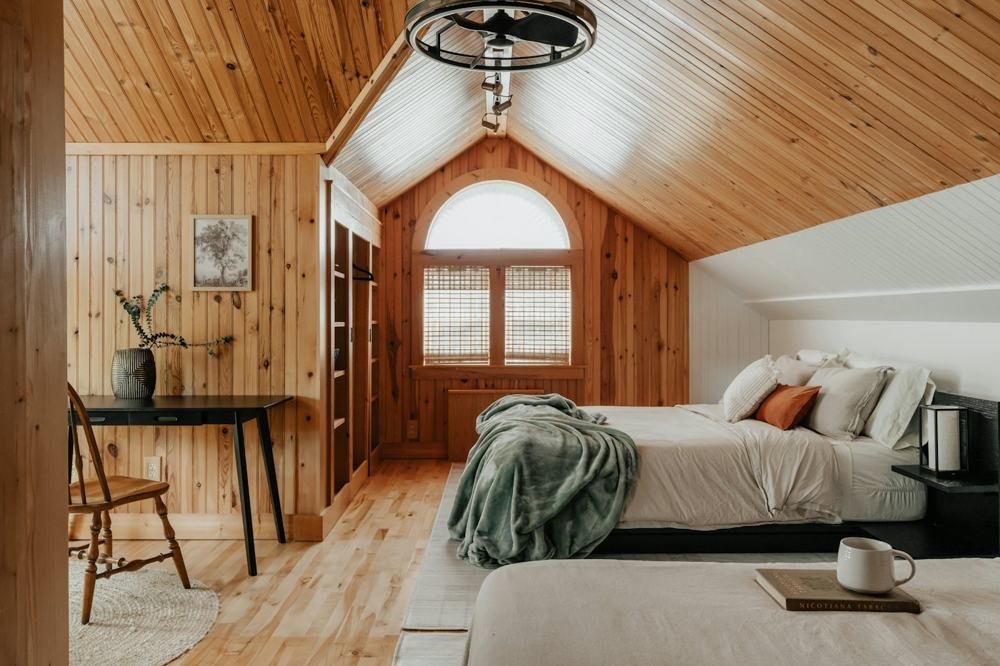 Schlafzimmer aus Holz mit Bogenfenster